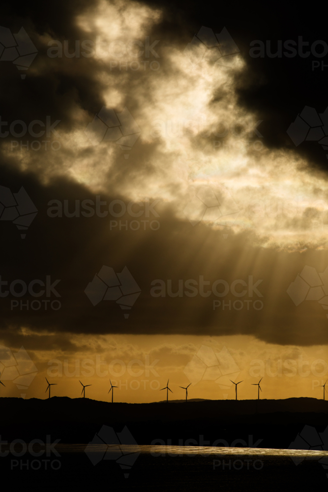 Wind turbines and golden rays and moody clouds - Australian Stock Image