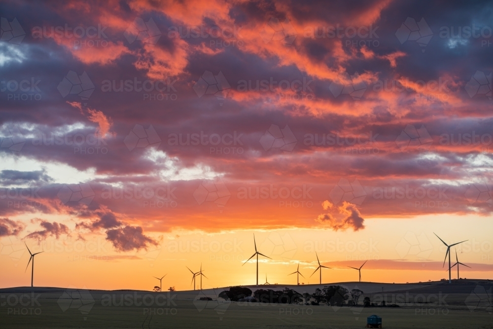 wind turbines in farmland against sunset sky - Australian Stock Image
