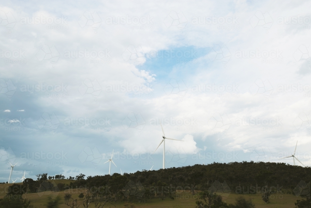 Wind turbines on a hill on a cloudy day - Australian Stock Image