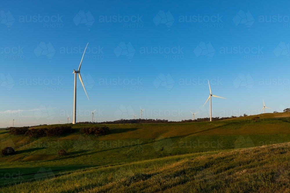wind turbines on hilltops against blue sky - Australian Stock Image