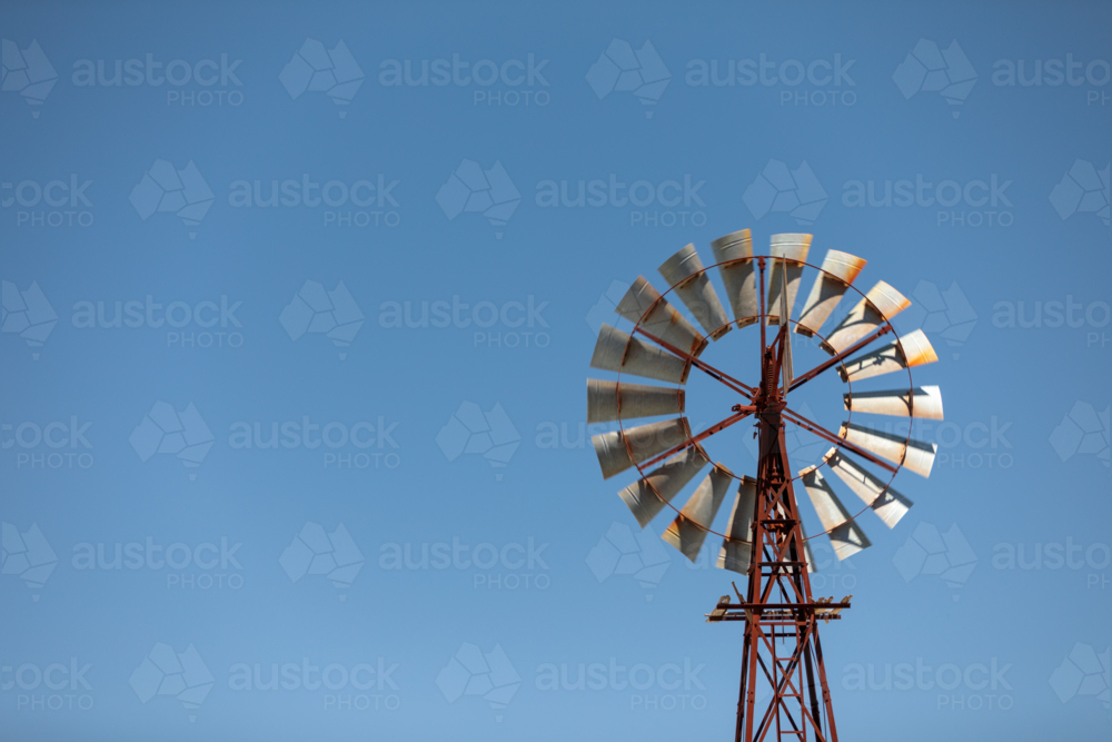 Windmill against bright blue summer sky - Australian Stock Image