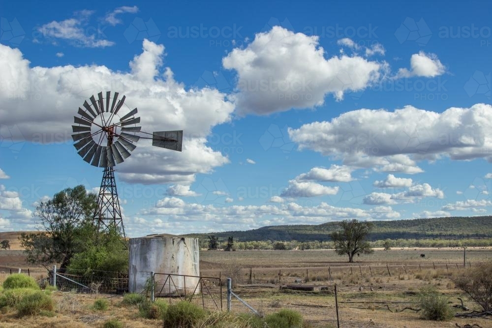 Windmill and water tank in a paddock - Australian Stock Image