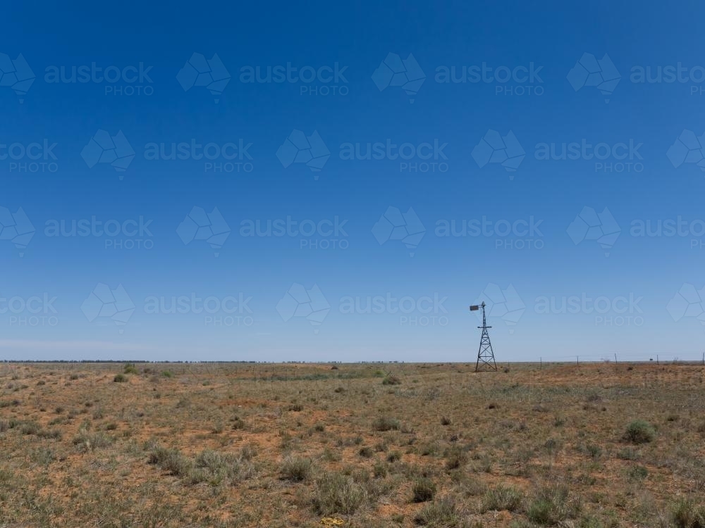 Windmill in arid landscape - Australian Stock Image