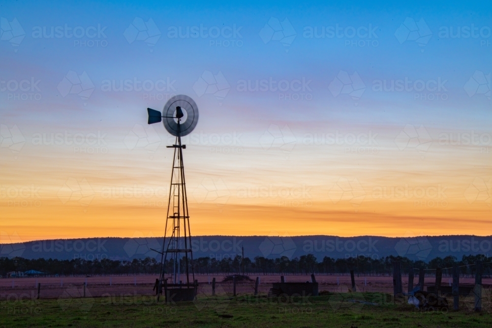 Windmill in the early dawn in a rural community - Australian Stock Image