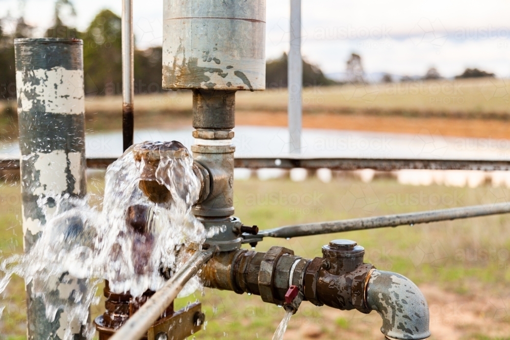 Windmill pumping water from one dam to another to clean it - Australian Stock Image