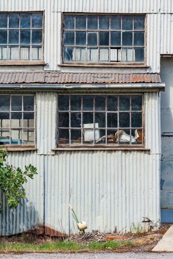Window panes in the side of an old corrugated iron factory - Australian Stock Image