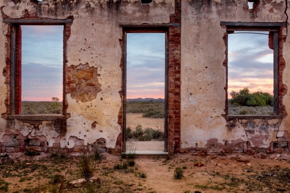 Window views from abandoned rustic ruin of a pretty desert sunrise - Australian Stock Image