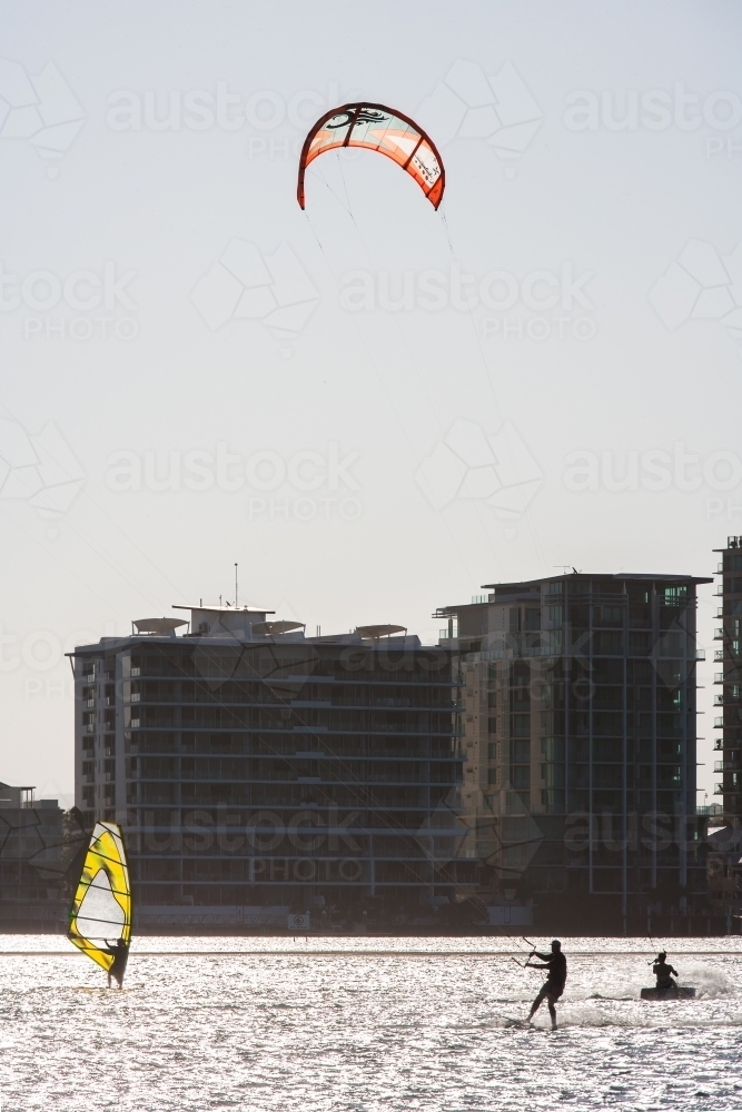 Windsurfing and kitesurfing at a river in a city - Australian Stock Image