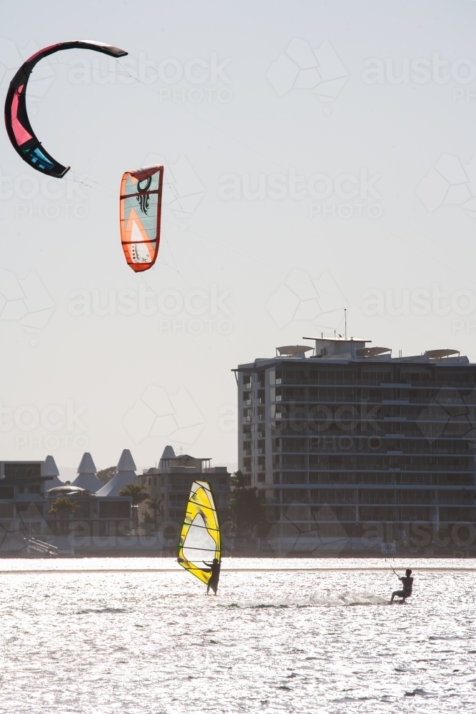 Windsurfing and kitesurfing at a river in a city - Australian Stock Image