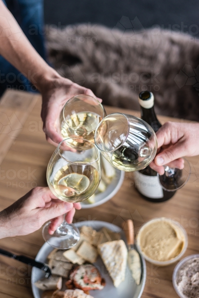 wine toast, three people clinking glasses - Australian Stock Image