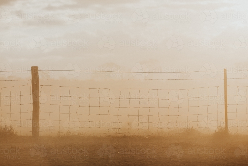Wire fence in brown haze - Australian Stock Image