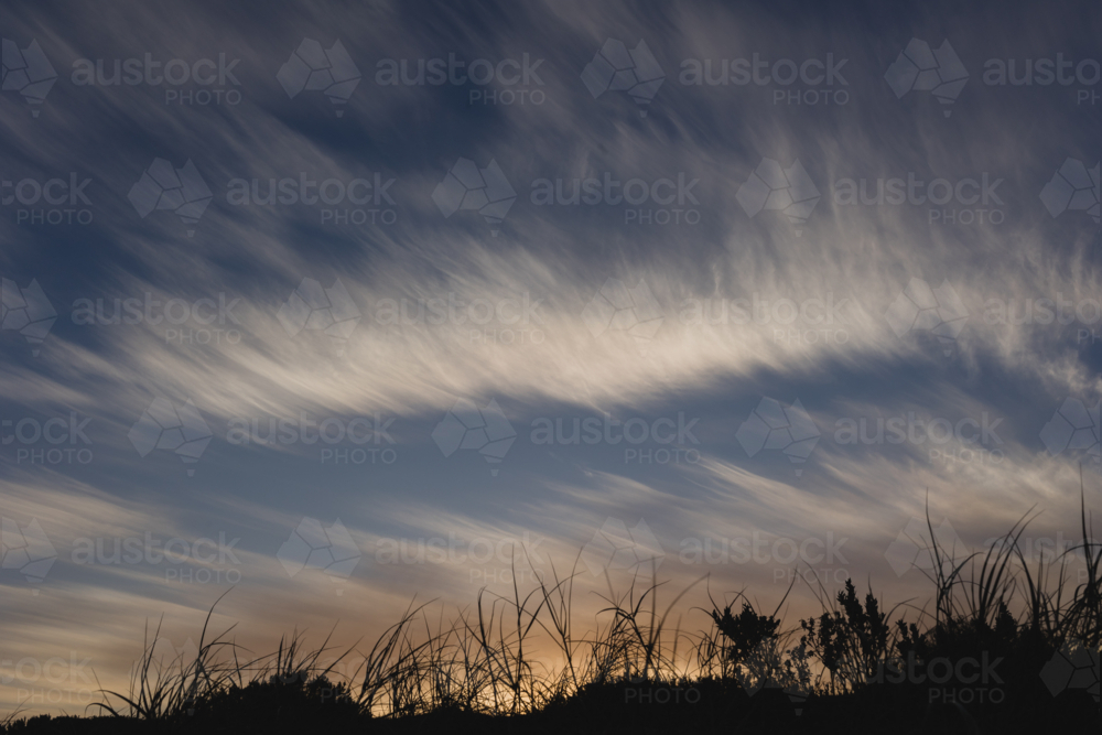 Wispy clouds at sunset over coastal dunes - Australian Stock Image