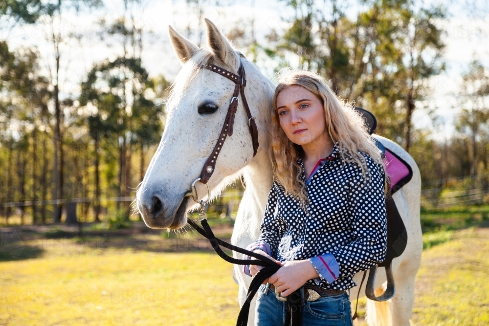 Wistful dreamy look on  young woman with her horse - Australian Stock Image