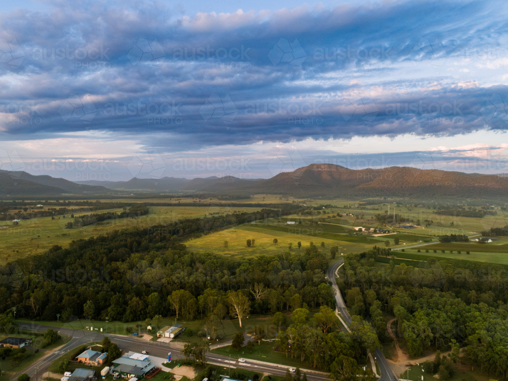 Wollombi Brook winding through green landscape in Broke NSW at first light of day - Australian Stock Image