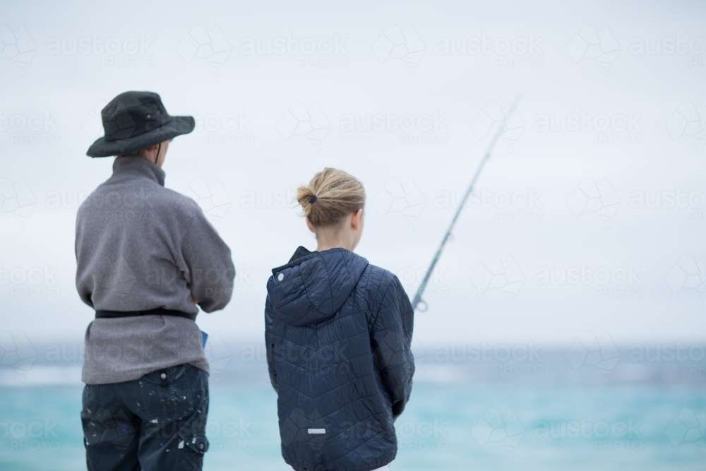 Woman and child fishing in the ocean - Australian Stock Image