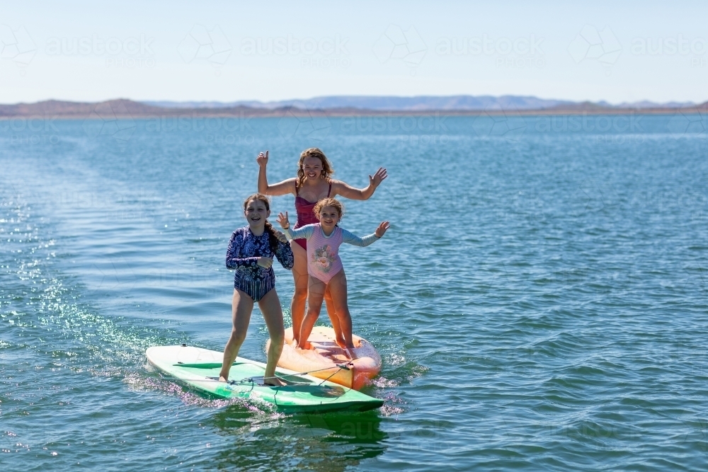woman and children having fun on paddleboards on Lake Argyle - Australian Stock Image
