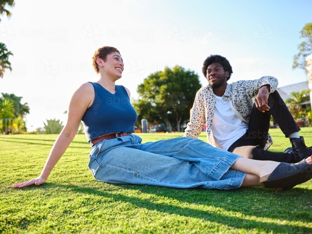 Woman and man sitting together in a park - Australian Stock Image