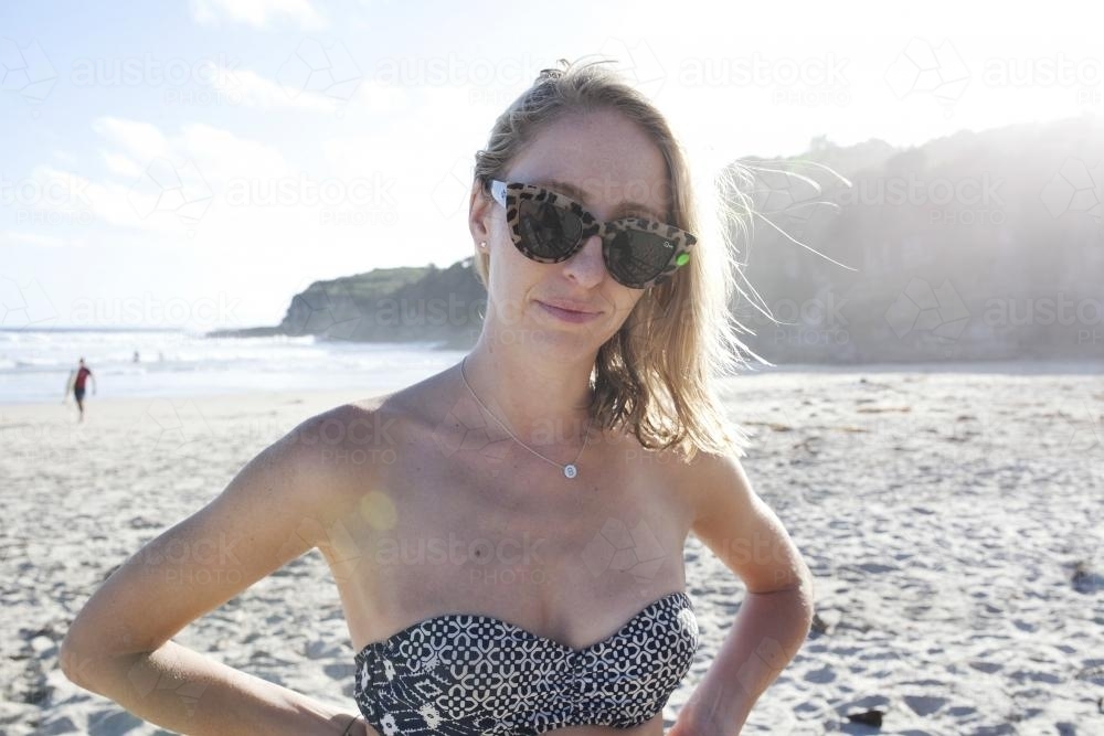 Woman at beach with sunglasses on - Australian Stock Image