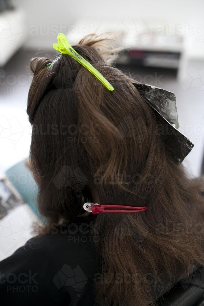 Woman at hairdressing salon from behind with hair clipped back - Australian Stock Image