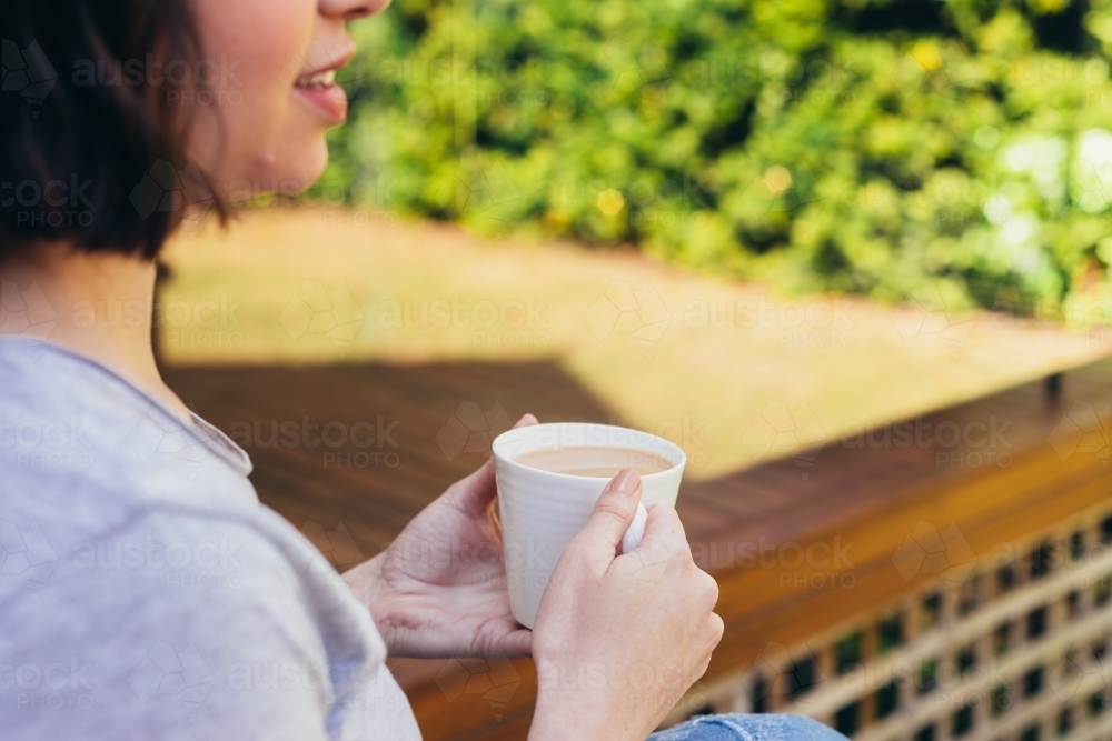 woman at home with cup of tea - Australian Stock Image