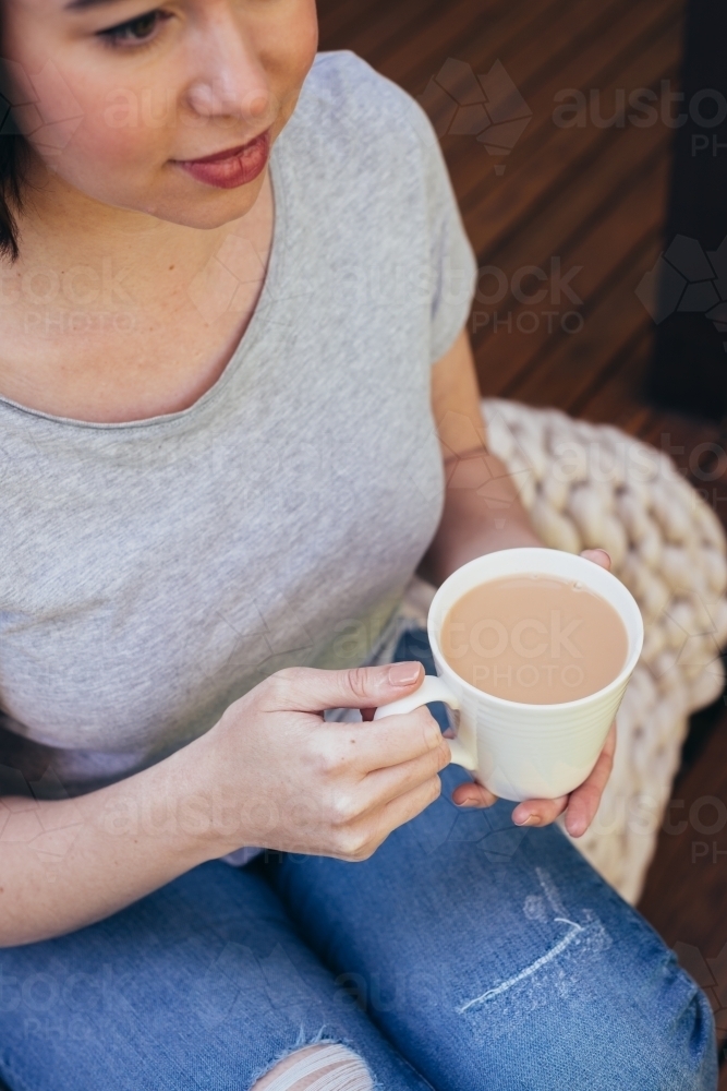 woman at home with cup of tea - Australian Stock Image