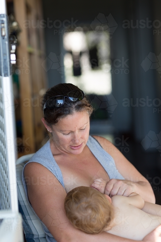 Woman breastfeeding baby at home - Australian Stock Image