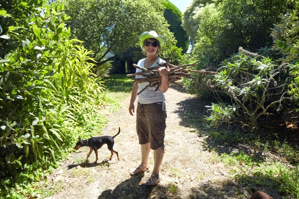 Woman collecting kindling firewood on her rural property - Australian Stock Image