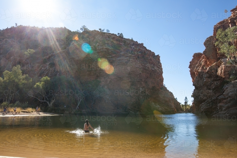 Woman cooling off in outback pool - Australian Stock Image