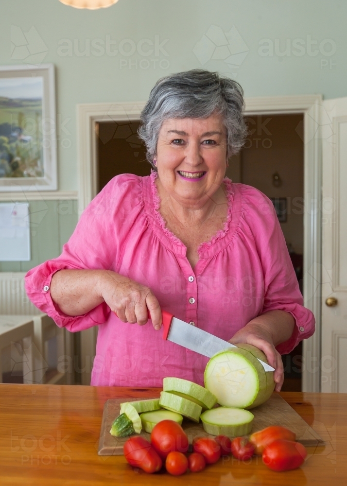 Woman cutting vegetables - Australian Stock Image