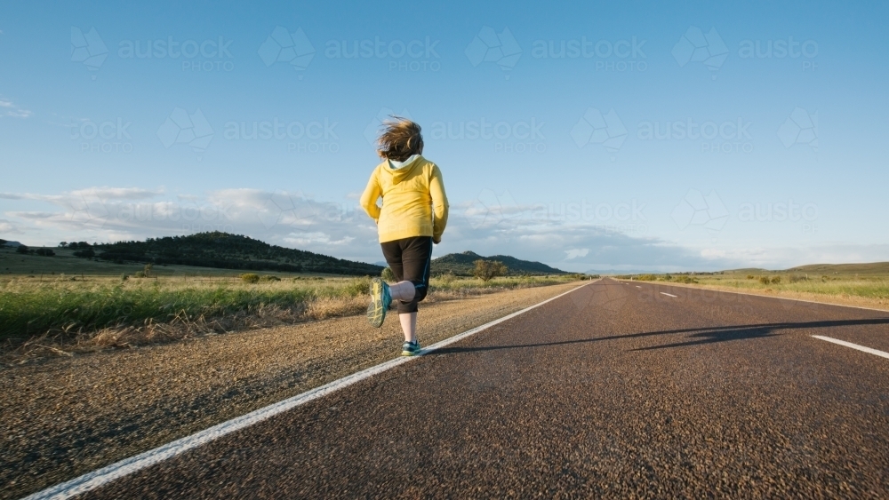 Woman doing exercise on a remote country road - Australian Stock Image