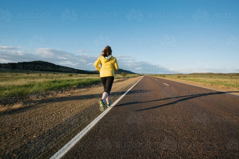 Woman doing exercise on a remote country road - Australian Stock Image