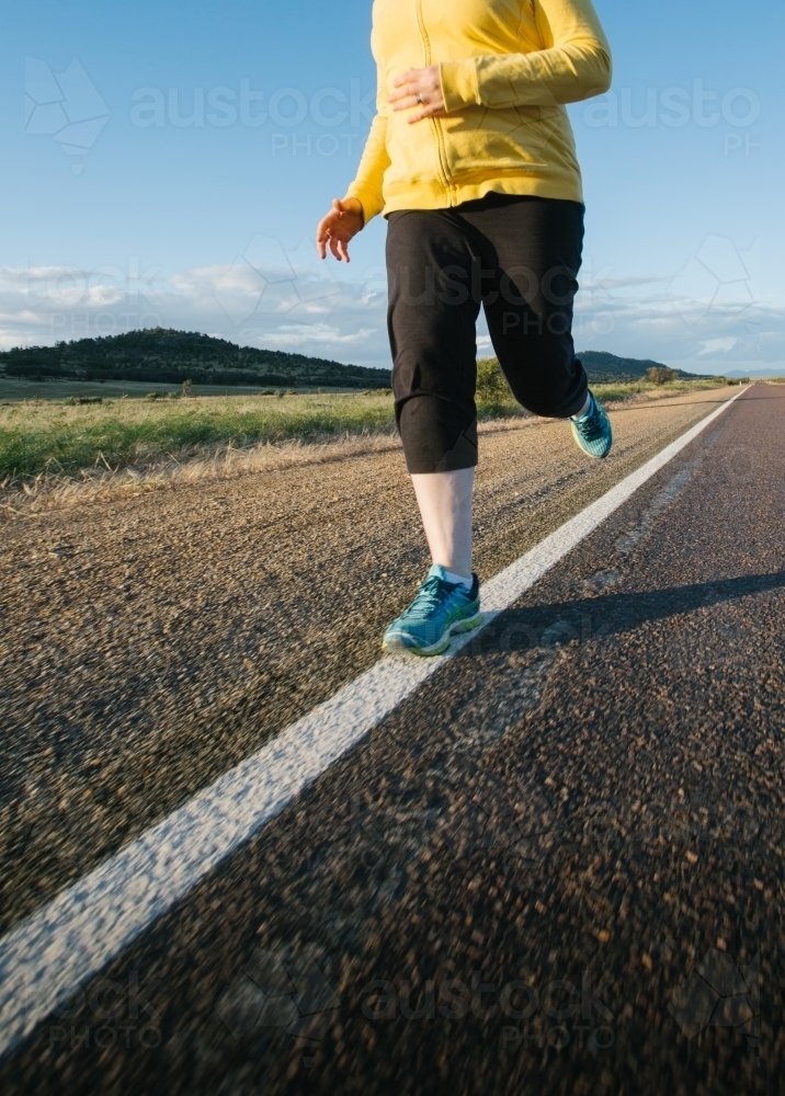 Woman doing exercise on a remote country road - Australian Stock Image