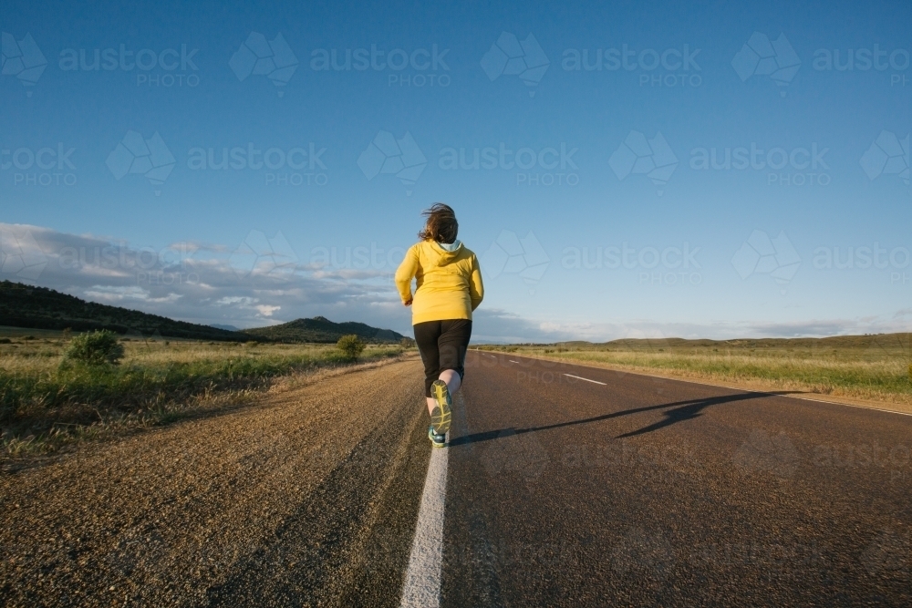 Woman doing exercise on a remote country road - Australian Stock Image