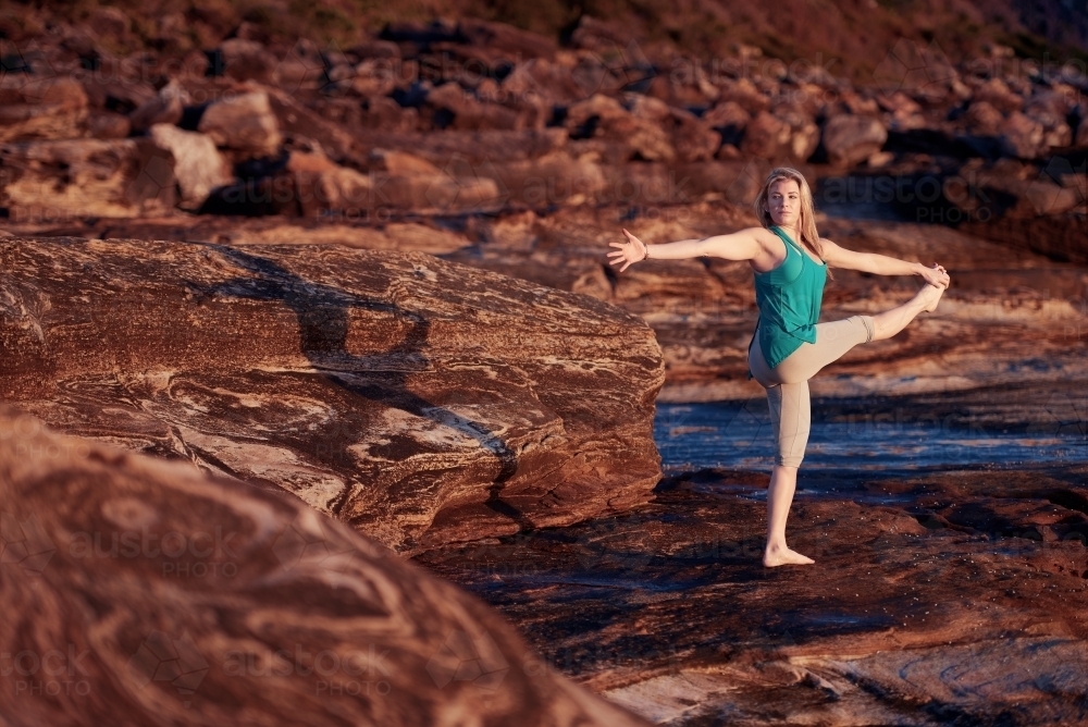 Woman doing yoga by the ocean - Australian Stock Image