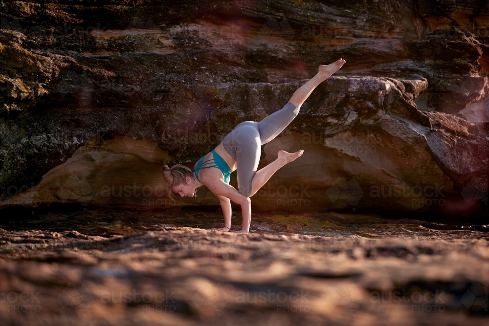 Woman doing yoga by the ocean - Australian Stock Image