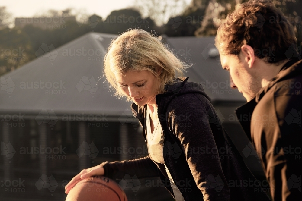Woman dribbling basketball in one on one game - Australian Stock Image