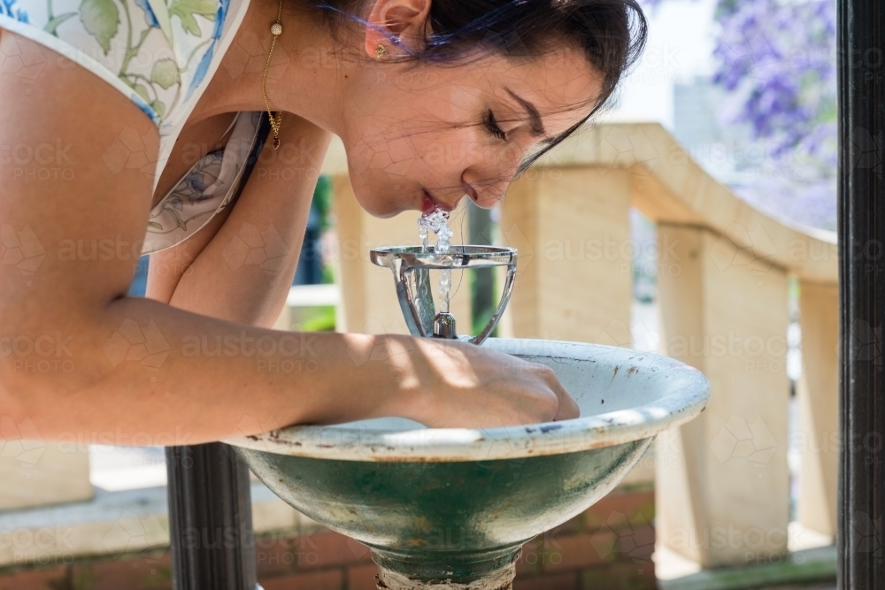 woman drinking at water fountain - Australian Stock Image