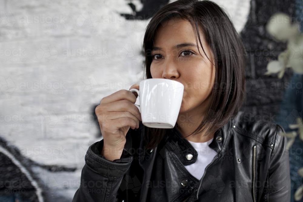 Woman drinking coffee from a mug - Australian Stock Image
