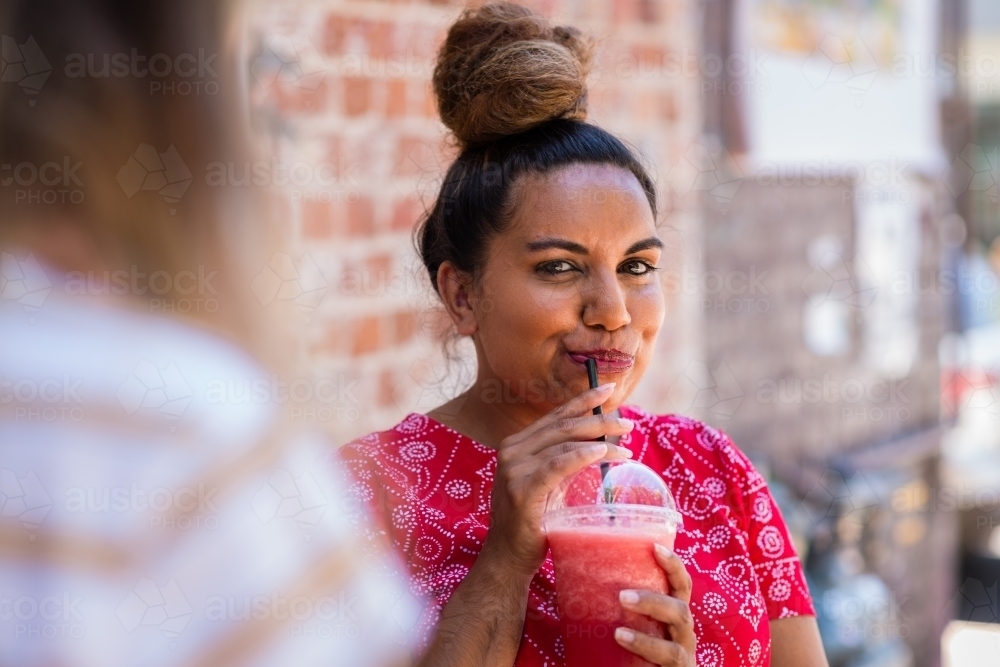 woman drinking fruit smoothie - Australian Stock Image