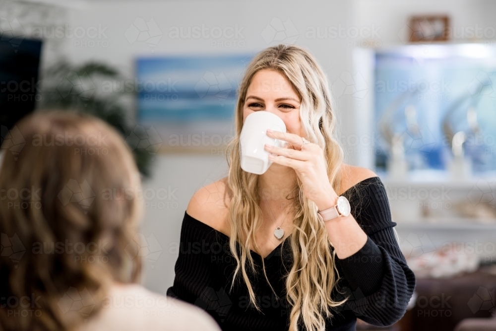 woman drinking tea, in the kitchen - Australian Stock Image