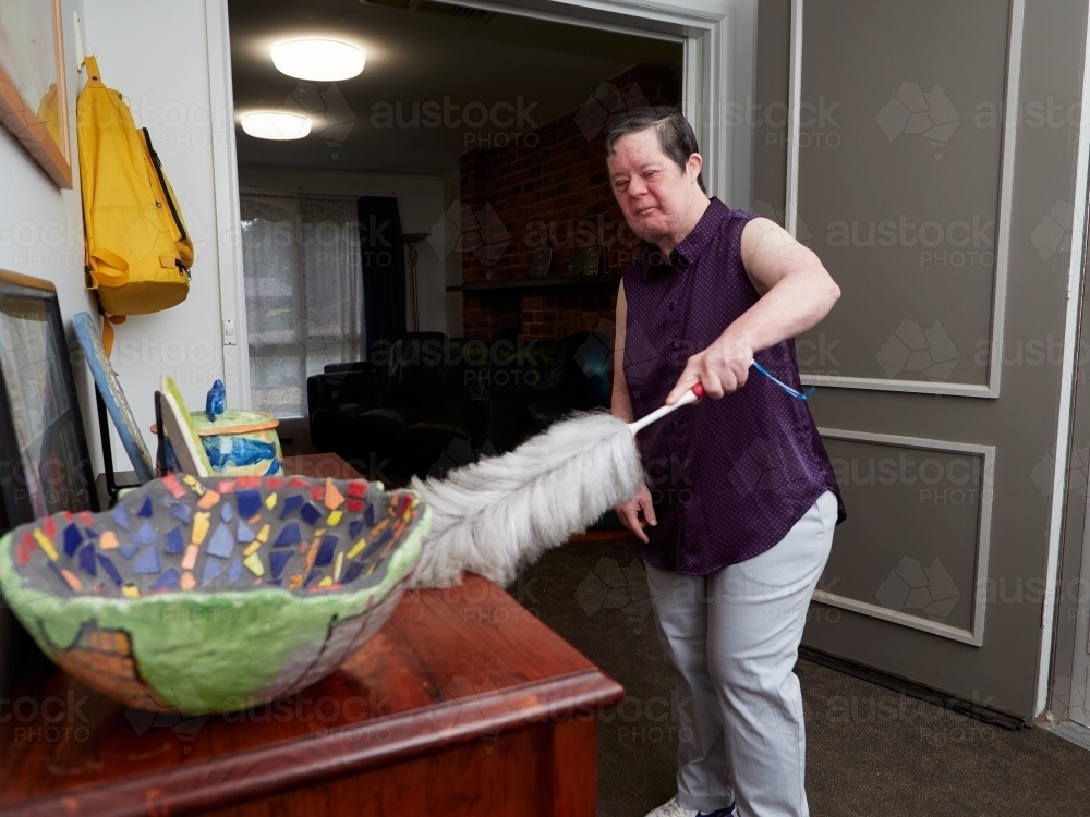 Image of Woman Dusting at Home - Austockphoto