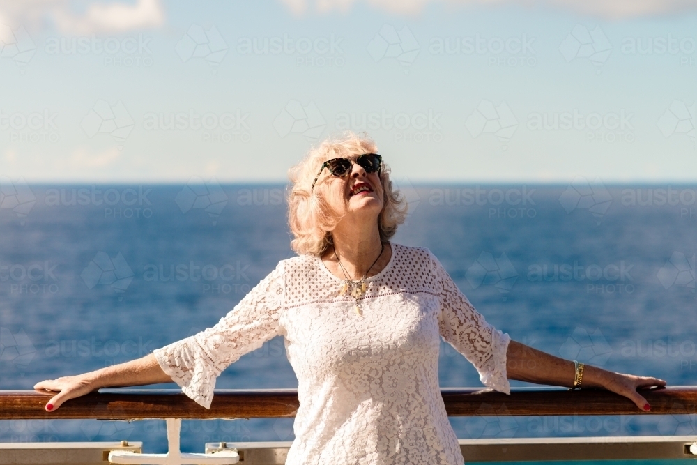 woman enjoying the sun on the deck of a cruise ship - Australian Stock Image