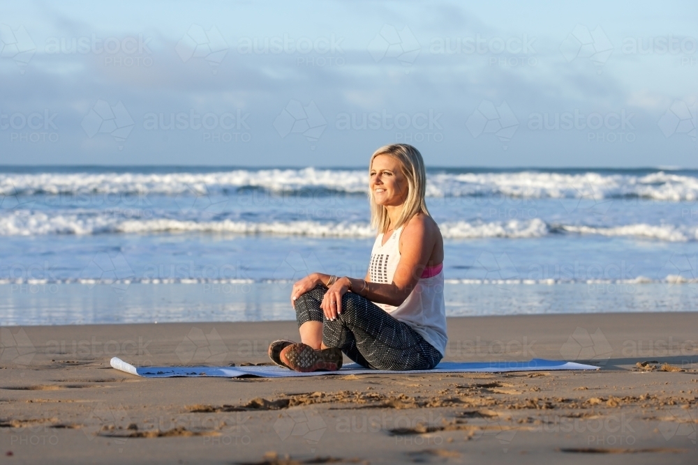 Woman exercising on a beach - Australian Stock Image
