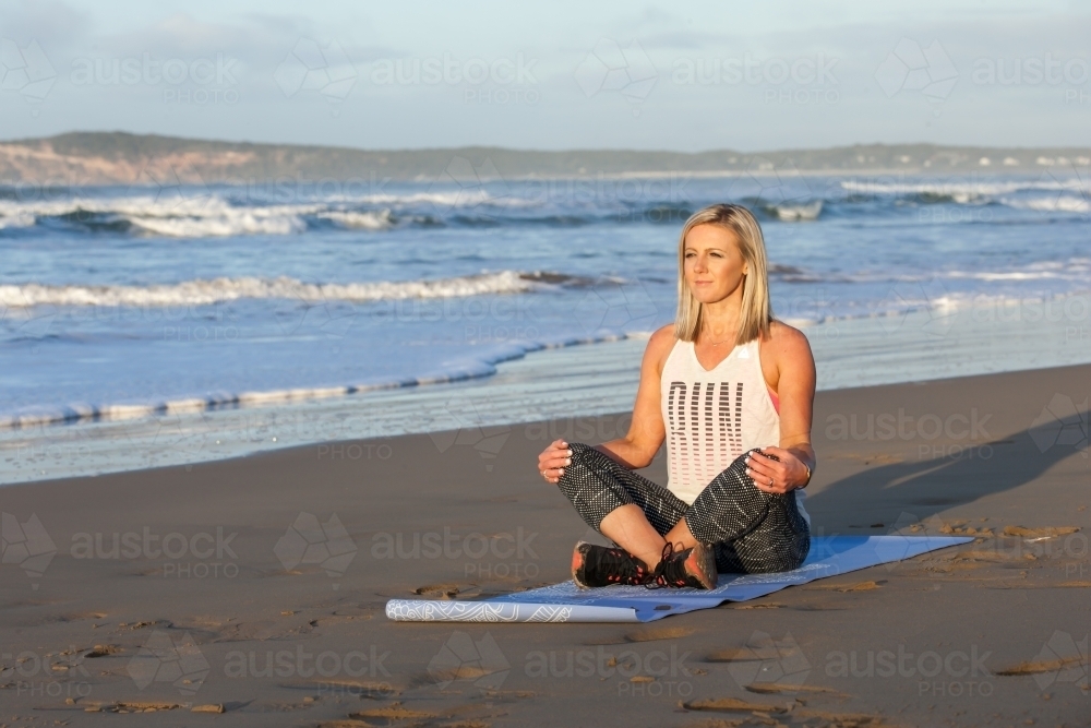 woman exercising on a beach in the early morning - Australian Stock Image