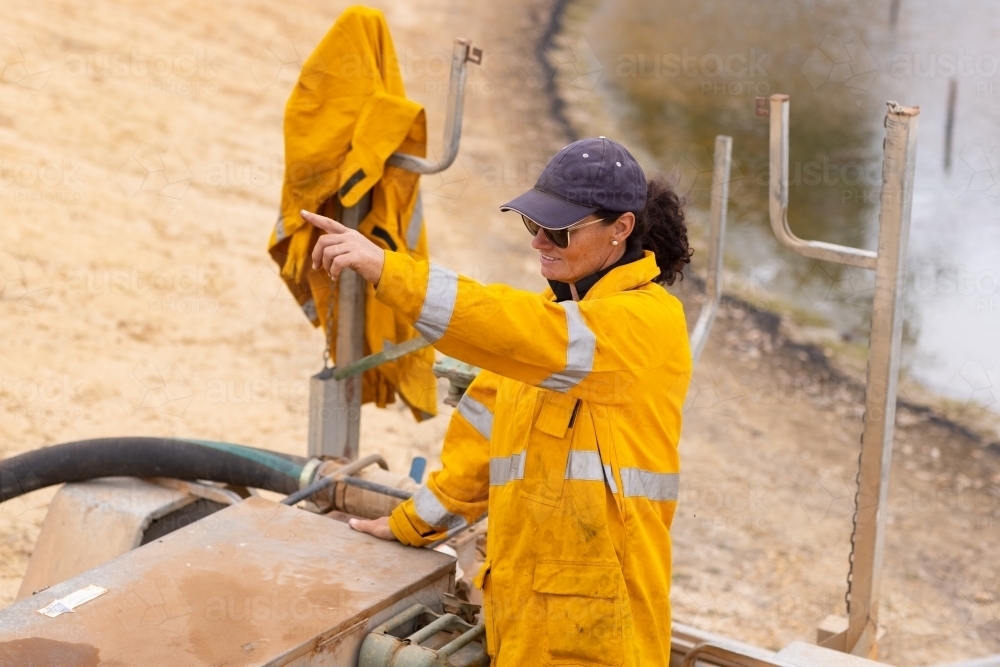 Woman firefighter looking and pointing away from her - Australian Stock Image