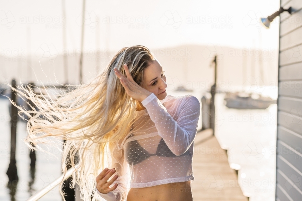 woman flipping her long blonde hair - Australian Stock Image