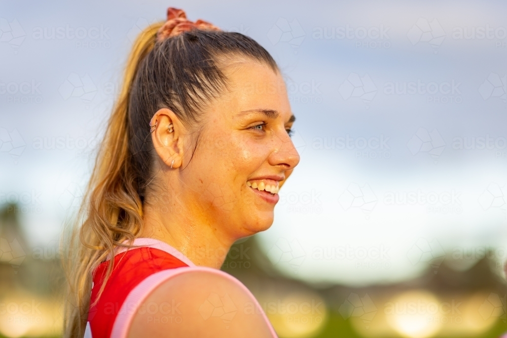 woman footballer with sun on her face highlighting the sweat - Australian Stock Image