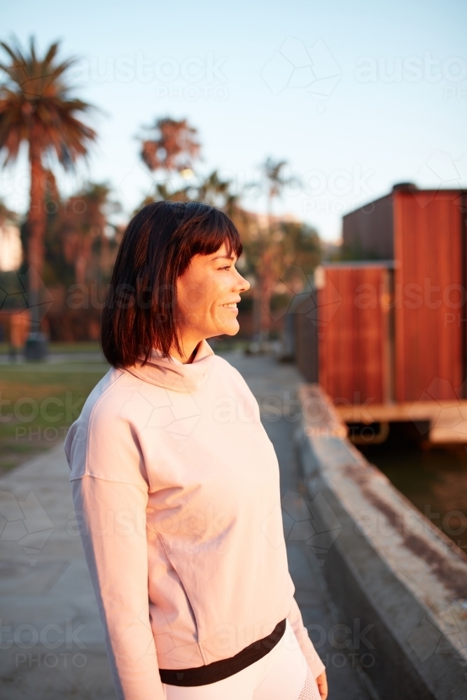 Woman harbourside in a happy mood at sunrise - Australian Stock Image