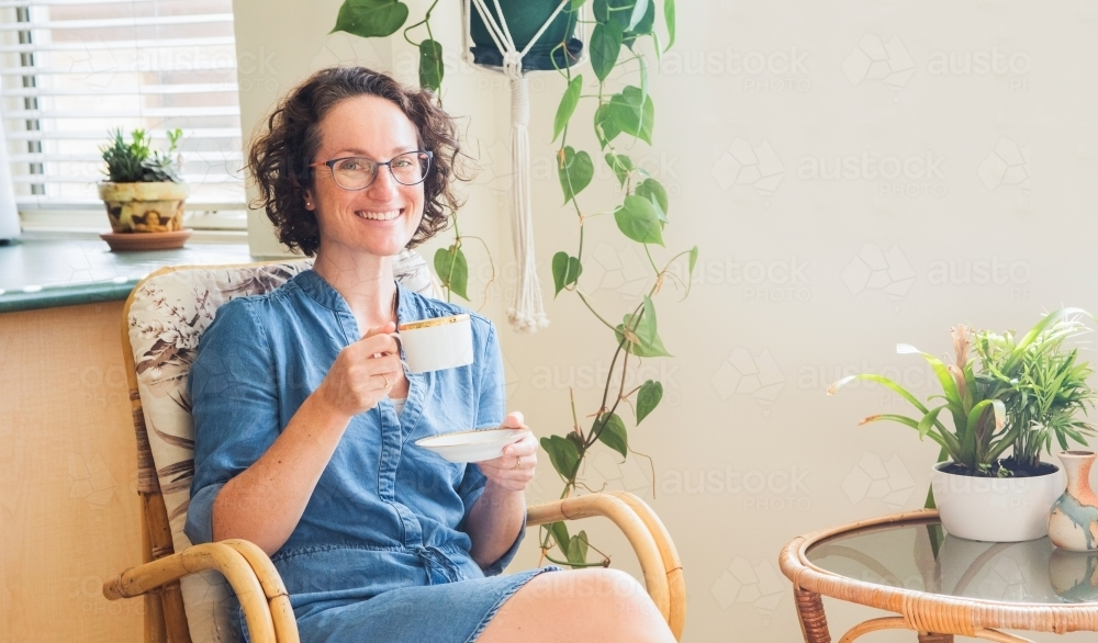 Woman having a cup of tea in her home - Australian Stock Image