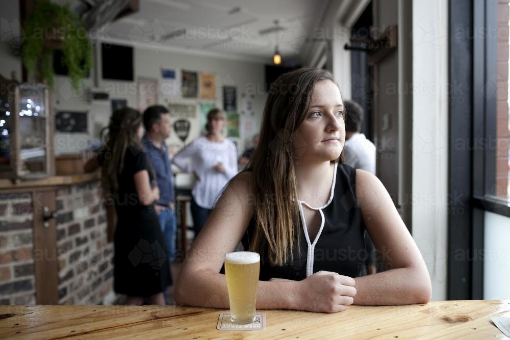 Woman having a drink at local craft beer bar - Australian Stock Image